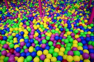 Viele bunte Plastikbälle in einem Bällebad für Kinder auf einem Spielplatz. Muster schließen foto