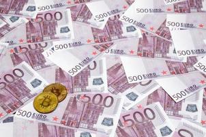 Bitcoins über Stapel von fünfhundert Euro-Banknoten. traditionelles geld versus kryptowährungskonzept. Goldmünze über 500-Euro-Scheine. Nahansicht foto