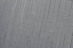 die textur der wand aus den alten fliesen, grau gestrichen unter dem einfluss von kondensation. Viele kleine Tropfen und Wasserflecken an der Wand foto