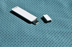Auf der blauen Sportbekleidung aus Polyester-Nylonfaser wird ein moderner tragbarer USB-WLAN-Adapter platziert foto