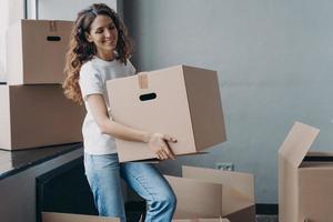 lächelndes Mädchen, das einen Karton mit Dingen für Spenden, Wohltätigkeitszwecke trägt. Tätigkeit einer gemeinnützigen Organisation foto