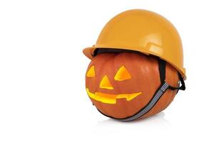 Halloween, orangefarbener Kürbis mit gelbem Bauhelm, Schutzhelm. weißer Hintergrund. foto