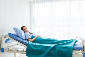 junge asiatische Patientin, die auf Bett im Krankenhaus liegt foto