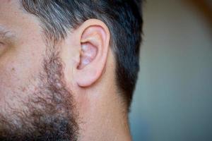 männliche Körperteile, Bart und Ohr, Nahaufnahme foto