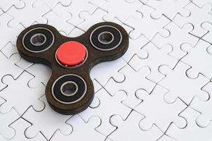 Ein hölzerner Spinner liegt auf einem weißen Puzzle-Hintergrund foto