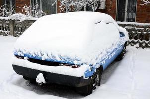 Foto eines Autos, das mit einer dicken Schneeschicht bedeckt ist. Folgen von starkem Schneefall