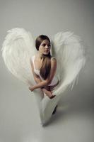 romantisches engelsmädchen mit weißer flügeldraufsicht foto