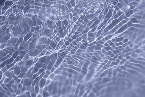 defocus verschwommene, transparente, blaue, klare, ruhige wasseroberflächenstruktur mit spritzer, blase. glänzender blauer wasserkräuselungshintergrund. Wasseroberfläche im Schwimmbad. blaues Blasenwasser scheint. foto