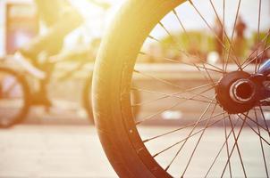 ein bmx-fahrradrad vor dem hintergrund einer unscharfen straße mit radfahrern. Extremsportkonzept foto