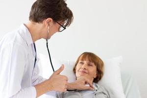 Der Arzt untersucht den Patienten im Krankenhaus. weißer männlicher arzt, der eine ältere weiße patientin untersucht. foto