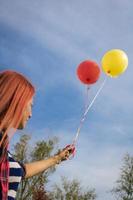 Unten Ansicht der Frau mit bunten Luftballons gegen den Himmel. foto