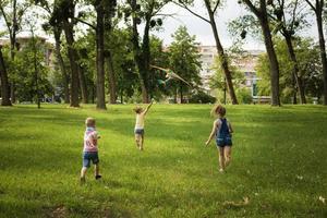 Rückansicht von Kindern, die Drachen in der Natur fliegen. foto