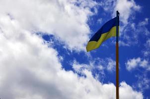 ukrainische Flagge gegen den blauen Himmel mit Wolken. Die offizielle Flagge des ukrainischen Staates umfasst gelbe und blaue Farben foto