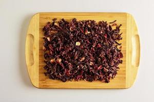 Tee aus getrockneten Granatapfelblüten. erhöht die Immunität. Hintergrund von duftendem Tee auf einem Holzbrett foto