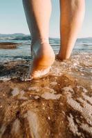 Füße laufen in Sand und Wasser