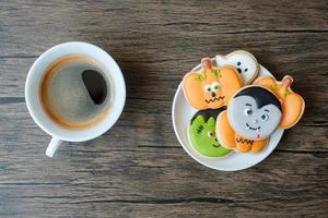 Kaffeetasse und lustige Halloween-Kekse. glücklicher halloween-tag, trick oder bedrohung, hallo oktober, herbstherbst, traditionelles, party- und feiertagskonzept foto