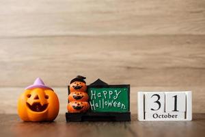 glücklicher halloween-tag mit jack-o-lanternkürbis und kalender vom 31. oktober. trick oder bedrohung, hallo oktober, herbst, festliches, party- und feiertagskonzept foto