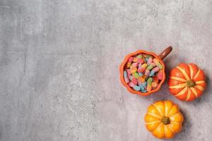 fröhlicher halloween-tag mit geisterbonbons, kürbis, schüssel und dekorativ. trick oder bedrohung, hallo oktober, herbst, festliches, party- und feiertagskonzept foto