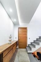 verteiler eines modernen hauses, mit treppe und licht am fuß, holzschrank, tür holz foto