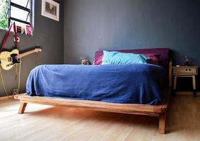 Lattenrost, Schlafzimmer mit Matte auf dem Boden, Tontopf im Hintergrund, Anrichte und Spiegel aus Holz. foto