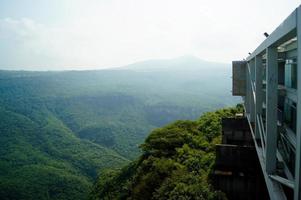 Blick auf eine natürliche Schlucht mit grüner Vegetation, Schulgebäude aus Stahl und Glas mit Blick auf die Schlucht foto