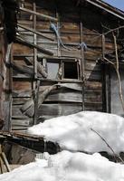 Schnee häuft sich vor einem alten Holzhaus in Kusatsu Onsen, Japan foto