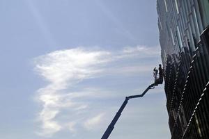 Arbeiter putzen die Fenster des Opernhauses in Reykjavik foto