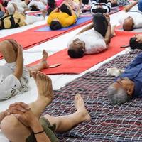 neu-delhi, indien, 19. juni 2022 - gruppen-yoga-übungssitzung für menschen verschiedener altersgruppen im balaji-tempel, vivek vihar, internationaler yoga-tag, große gruppe von erwachsenen, die an yoga-kursen im tempel teilnehmen foto