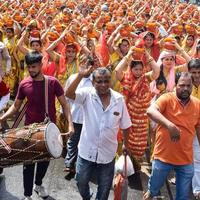 neu delhi, indien 03. april 2022 - frauen mit kalash auf dem kopf während des jagannath-tempels mangal kalash yatra, indische hindu-anhänger tragen irdene töpfe mit heiligem wasser mit einer kokosnuss darauf foto