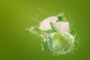 Wasser spritzt auf grüne Guavenfrucht