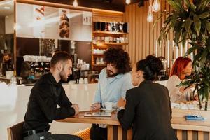 eine Gruppe von Freunden, die in einem Café abhängen, und unter ihnen ist ein Tablet. foto