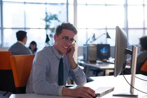 Geschäftsmann, der mit einem Computer im Startup-Büro arbeitet foto