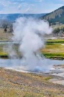 Geysir, der im Geysir-Becken im Yellowstone-Nationalpark ausbricht foto