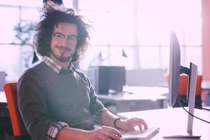 Geschäftsmann, der mit einem Computer im Startup-Büro arbeitet foto