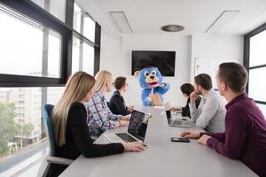 als bär verkleideter chef hat spaß mit geschäftsleuten im trendigen büro foto