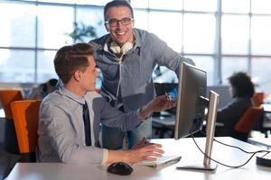 zwei geschäftsleute, die mit computer im büro arbeiten foto