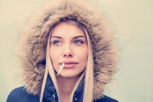 Porträt eines jungen blonden Mädchens mit Zigarette im Mund foto