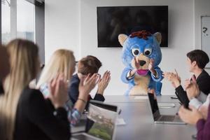 als bär verkleideter chef hat spaß mit geschäftsleuten im trendigen büro foto