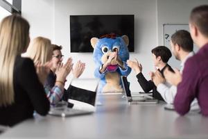 als bär verkleideter chef hat spaß mit geschäftsleuten im trendigen büro foto