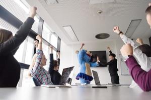 als bär verkleideter chef hat spaß mit geschäftsleuten im trendigen büro foto