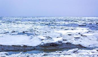 gefrorener fluss meer auf deich schnee eisschollen glattes eis. foto