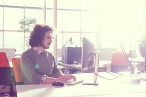 Geschäftsmann, der mit einem Computer im Startup-Büro arbeitet foto