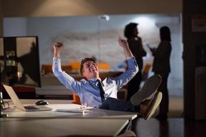 Geschäftsmann sitzt mit Beinen auf dem Schreibtisch im Büro foto