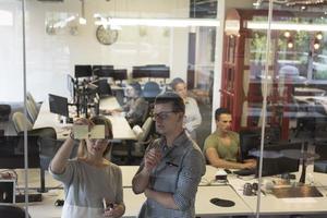 junges paar im modernen büroinnenraum, das notizen auf aufklebern schreibt foto