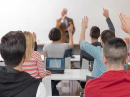 studentengruppe hebt die hände in der klasse foto