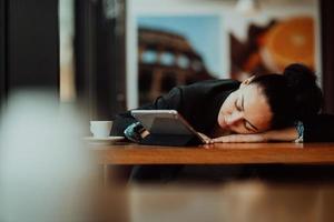 Lifestyle freiberufliche Frau, die er nach langer harter Arbeit im Café ausruhen und schlafen lässt foto