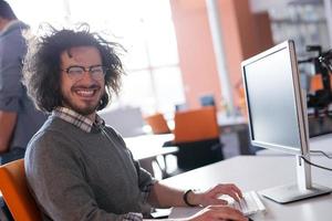 Geschäftsmann, der mit einem Computer im Startup-Büro arbeitet foto