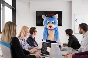 als bär verkleideter chef hat spaß mit geschäftsleuten im trendigen büro foto