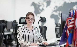 Gelegenheitsgeschäftsfrau, die an einem Desktop-Computer arbeitet foto