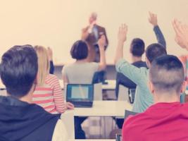 studentengruppe hebt die hände in der klasse foto